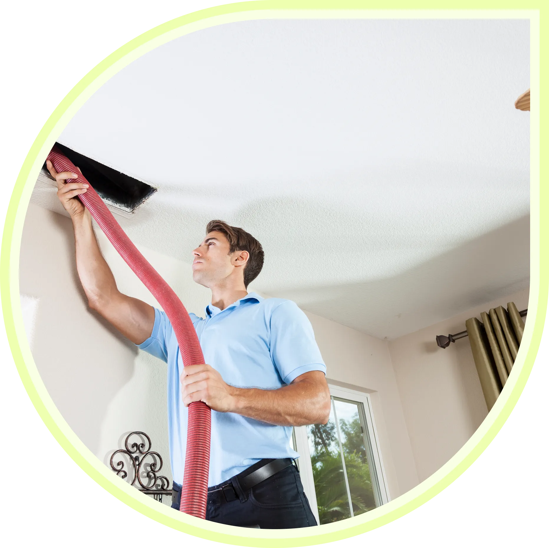 Man cleaning ceiling with vacuum hose.